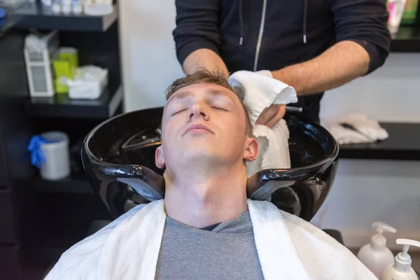 Young man on a haircut in the barber shop — Stock Photo, Image