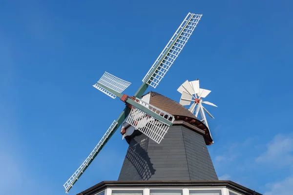 Dřevěný větrný mlýn proti modré obloze — Stock fotografie