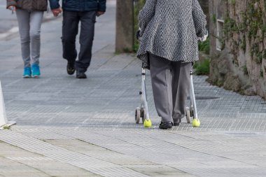 yaşlı kadın sokakta bir yürüyüşe gezici bir cihazla