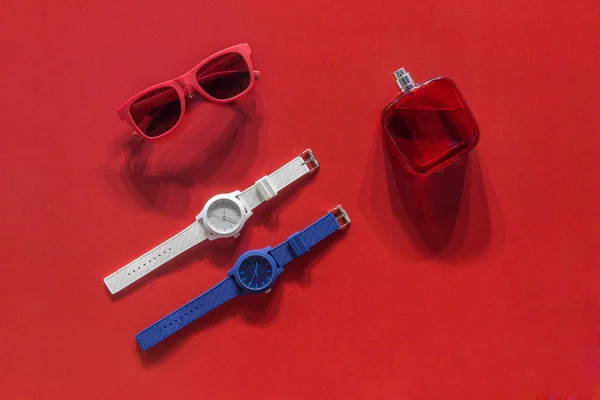 墨镜、 手表及花露水，背景为红色天鹅绒 — 图库照片