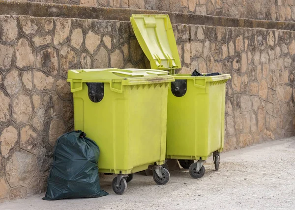 Groen afval containers in de buurt van de muur — Stockfoto