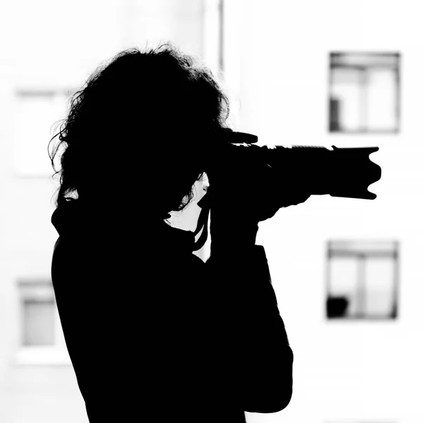 Monochrome silhouette of a woman with a SLR camera — Stock Photo, Image