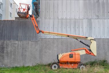 industrial lift on the street near the building wall clipart