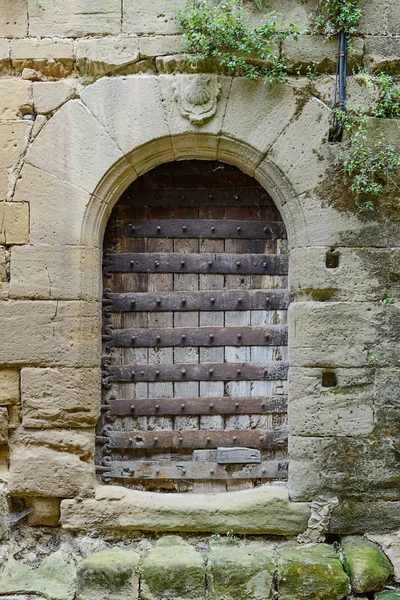 Ancienne porte en bois dans un mur de pierre — Photo