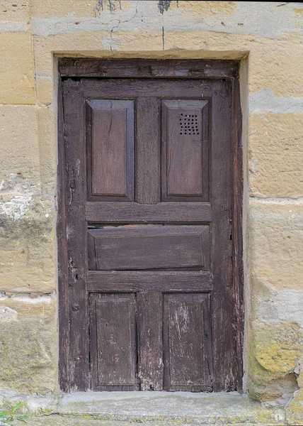 Staré dřevěné dveře v kamenné zdi — Stock fotografie