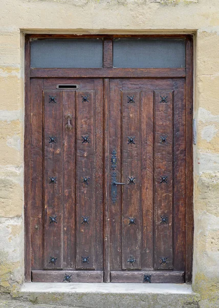 Muinainen puinen ovi kiviseinässä — kuvapankkivalokuva