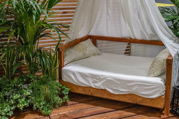 Кровать с балдахином на деревянном крыльце — стоковое фото