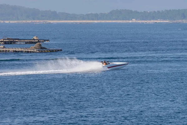 Jovens montam um barco a motor no mar — Fotografia de Stock