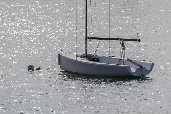 Парусник с спущенными парусами, пришвартованный у берега — стоковое фото