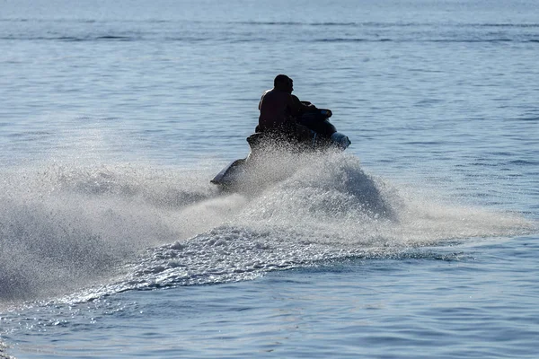 Muž na koni hydrocycle zadní pohled, podsvícení — Stock fotografie