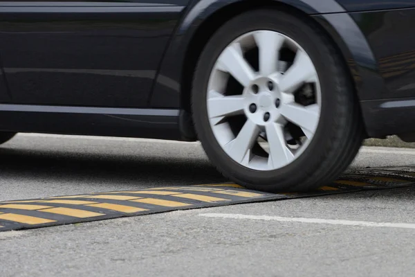 Auto fährt in Nahaufnahme durch eine Geschwindigkeitsbeule — Stockfoto