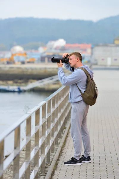 Молодий чоловік фотографує море з набережної — стокове фото
