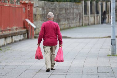 alışveriş torbaları sokakta yürüyen yaşlı adam