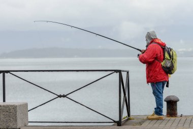 adam bir iskelede Balık tutma gezisinde
