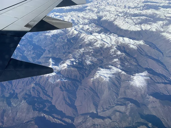 Vista de montanhas nevadas do pórtico de um avião — Fotografia de Stock