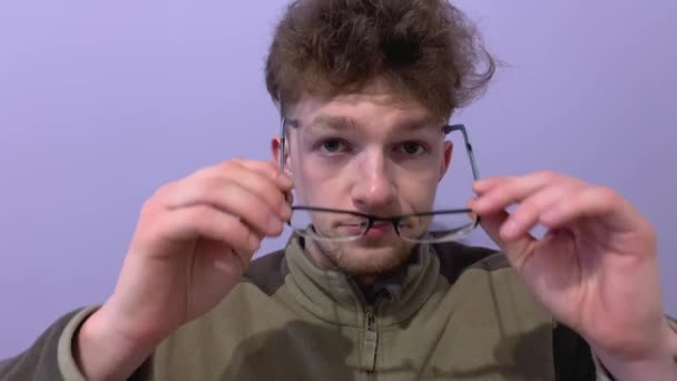 Mladý Muž Nasadí Brýle Dívá Tázavě Legrační Pohled Kamery Zblízka — Stock video