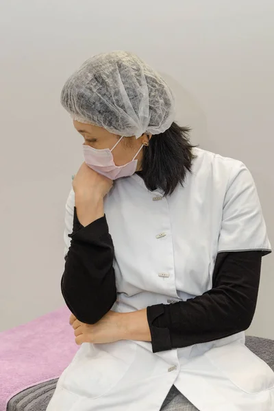 portrait of a tired asian nurse in medical mask