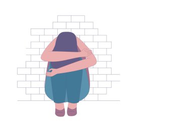 Depresyonda ya da üzgün kız tuğla duvarın yanında oturuyor..