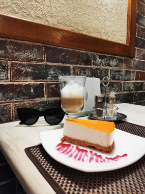 Cheesecake dilimi, arka planda peynirli kek. Tatlı çatalıyla beyaz bir tabakta lezzetli bir pasta dilimi