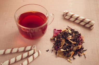 Kuru çay, su bardağı, şekerleme ahşap arka plan üzerinde