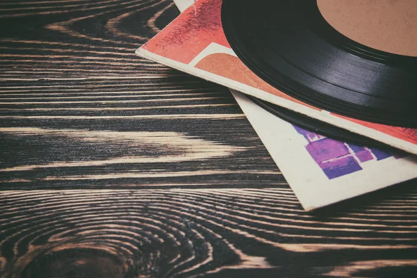 Oude vinyl record op de houten tafel — Stockfoto