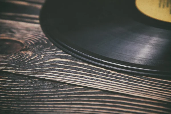 Oude vinyl record op de houten tafel — Stockfoto