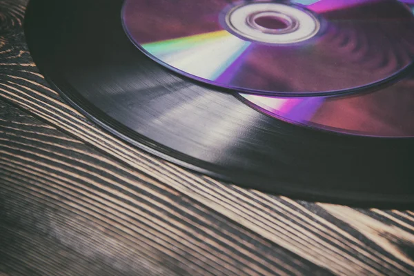 Oude en morden audio schijven op de houten tafel — Stockfoto