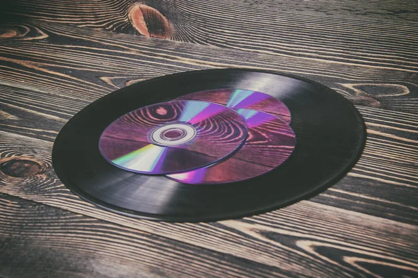 Oude en morden audio schijven op de houten tafel — Stockfoto