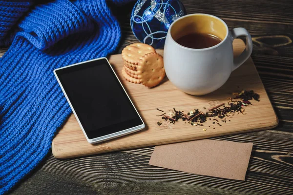 Tee und Smartphone im Mittelpunkt der süßen Weihnachtsdekoration — Stockfoto