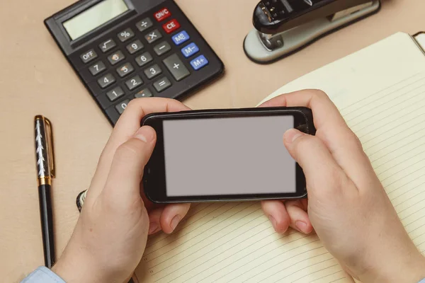 Primer plano de un hombre apuntando con el dedo al teléfono inteligente con un monitor de pantalla en blanco — Foto de Stock