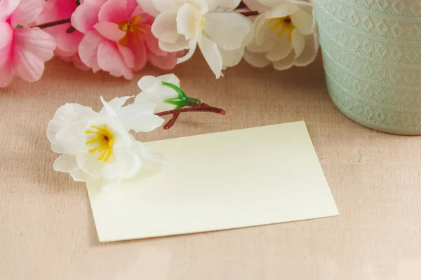 Tarjeta de felicitación en blanco con ramo de flores sobre fondo de madera blanca — Foto de Stock