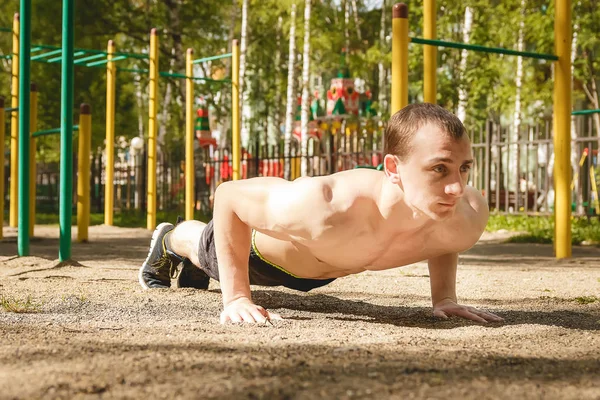 Fiatal sportos férfi gyakorló szabadban push-up. Egészséges életmód fogalma. — Stock Fotó