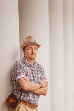 Neşeli şık adam açık havada duvara yaslanmış şapkalı