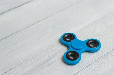 Mavi topluca spinner stres giderici oyuncak ahşap arka plan üzerinde