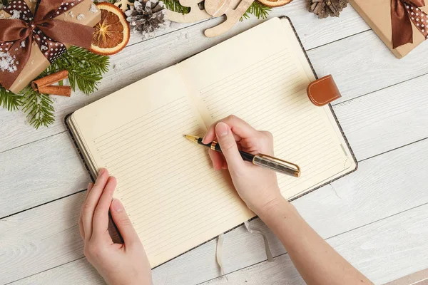 Noel süsler ve hafif ahşap masa üstünde açık bir boş defter