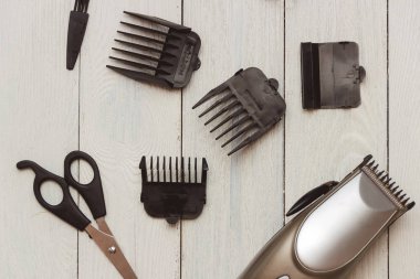 Şık profesyonel saç kesme makineleri, ahşap arka plan üzerinde aksesuarları