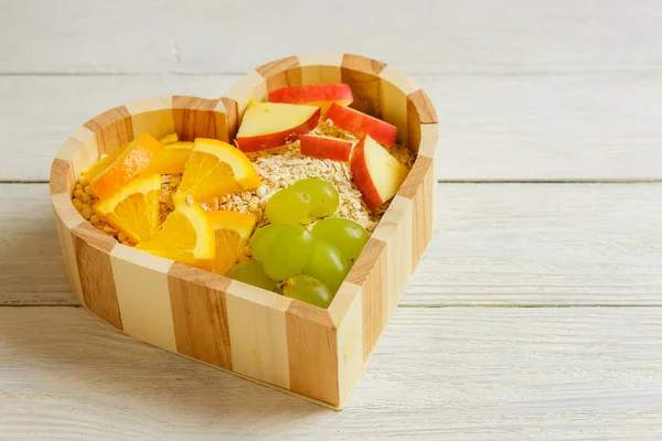 Fruits heart on the wooden background. Healthy food concept.