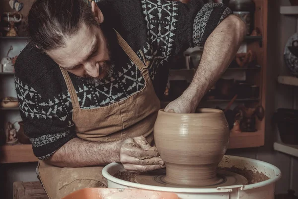 Uomo anziano che fa pentola usando la ruota in ceramica in studio — Foto Stock