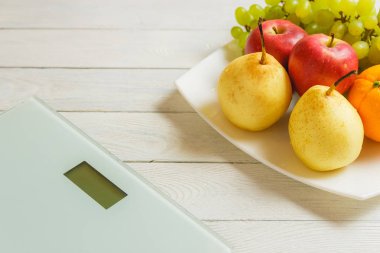 kat ölçek ve ahşap arka plan üzerinde meyve