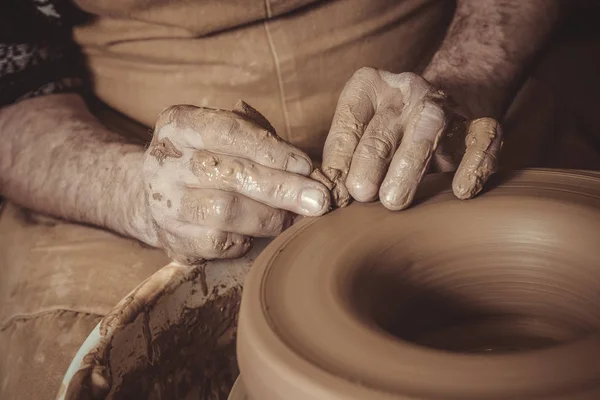 Літній чоловік робить горщик, використовуючи гончарне колесо в студії — стокове фото