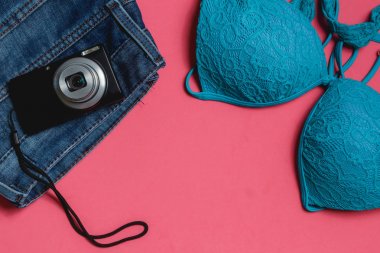 Mayo, kot pantolon, pembe bir arka plan üzerinde fotoğraf makinesi. Üstten Görünüm seyahat kavramı ile boşaltmak.