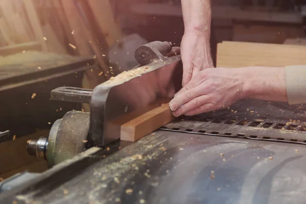 Cieśla praca na maszyny do obróbki drewna w sklepie stolarki. Męskiej ręki zbliżenie. — Zdjęcie stockowe