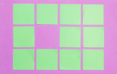 Lila kurulu bulunan yeşil etiket sabit, boş. Düz yatıyordu. Üstten Görünüm. Zaman yönetimi, planlama.