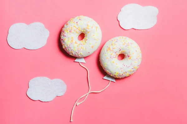 Donut på rosa, kreativ mat Minimalism, Donut i form av ballong i himlen med moln, ovanifrån med kopia utrymme, tonas — Stockfoto