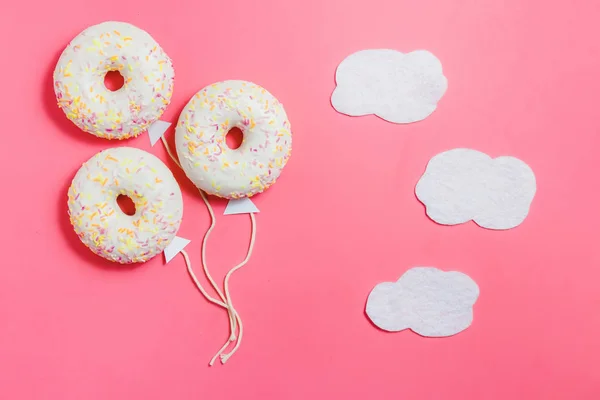 Donut på rosa, kreativ mat Minimalism, Donut i form av ballong i himlen med moln, ovanifrån med kopia utrymme, tonas — Stockfoto