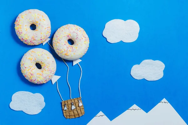 Creatieve voedsel minimalisme, Donut in de vorm van Aerostat in blauwe hemel met wolken, bergen, bovenaanzicht, kopie ruimte, Travel — Stockfoto