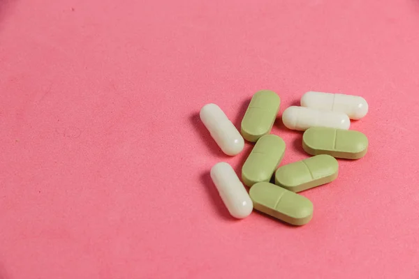 Асортимент таблеток, таблеток і капсул на рожевому столі . — стокове фото