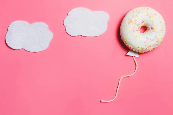 Donut på rosa, kreativ mat Minimalism, Donut i form av ballong i himlen med moln, ovanifrån med kopia utrymme, tonas — Stockfoto