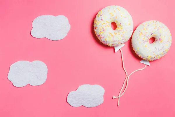 Donut på rosa, kreativ mat Minimalism, Donut i form av ballong i himlen med moln, ovanifrån med kopia utrymme, tonas — Stockfoto