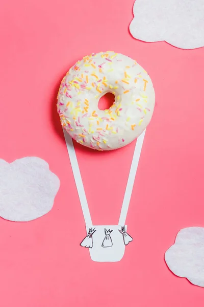 Donut op roze, creatieve voedsel minimalisme, Donut in de vorm van Aerostat in de hemel met wolken, bovenaanzicht met kopie ruimte, afgezwakt — Stockfoto
